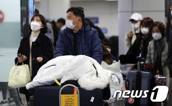 코로나19 확산 우려로 제주국제공항에 도착한 여행객들이 마스크를 쓰고 입국장에 들어서고 있다. 2020.1.29/뉴스1