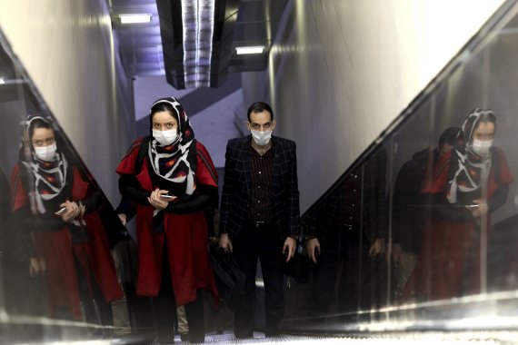 People wear masks to help guard against the Coronavirus as they ride an escalator at a the metro station, in Tehran, Iran, Sunday, Feb. 23, 2020. (AP Photo/Ebrahim Noroozi) /뉴시스/AP /사진=