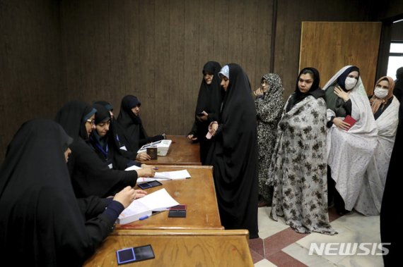 [테헤란=AP/뉴시스] 21일(현지시간) 이란 테헤란의 투표소에서 유권자들이 투표용지를 받고 있다. 이란 내무부는 지난 21일 실시된 총선의 투표율은 42%을 기록했다고 23일 발표했다. 1979년 이슬람 공화국이 시작된 이후 가장 낮은 참여율이다. 테헤란의 투표율도 20~25% 안팎으로 상당히 낮았다. 2020.2.23.
