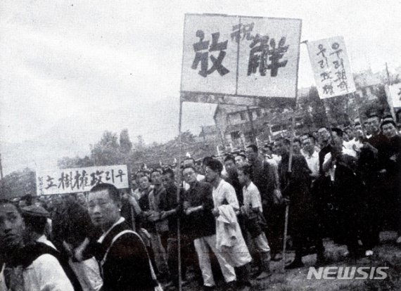 [서울=뉴시스]1945년 8월 16일 ‘우리 정권수립’, ‘축 해방’, ‘우리 조선 우리 정권’ 등의 현수막을 들은 군중들이 서울역 앞 광장에 서 있다. (사진=미디어한국학 제공) 2020.01.12. photo@newsis.com