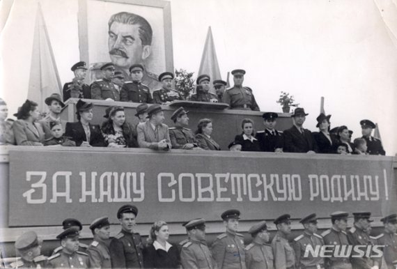 [서울=뉴시스] 1945년 7월 소련군 극동 최고사령관에 부임한 알렉산드르 바실리예프스키 원수가 일본 관동군과의 결전을 앞두고 극동군 총사령부가 있던 하바롭스크에서 군 장병과 가족들 앞에서 연설하고 있다. 한반도 진주 이후 미소공동위원회 소련 측 수석대표와 북한주재 초대 소련대사를 역임하는 티렌티 스티코프 연해주군관구 군사위원(상장)이 서 있다. 단상에 ‘우리 소비에트 조국을 위하여!’란 현수막이 걸려 있다. (사진=미디어한국학 제공) 2020.01.19. photo@newsis.com