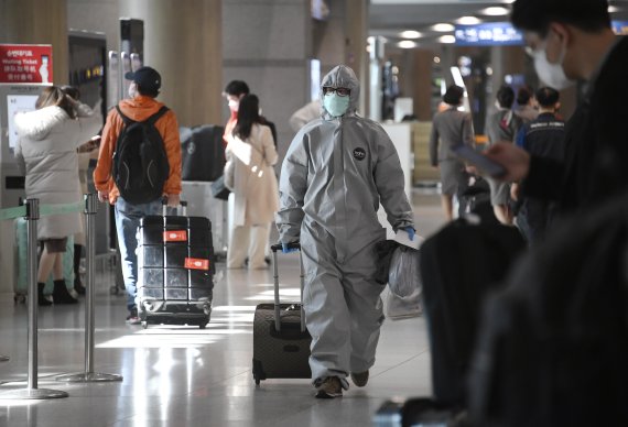 24일 인천공항에 방역복을 입고 입국한 중국유학생이 공항을 빠져나가고 있다. 사진=박범준 기자