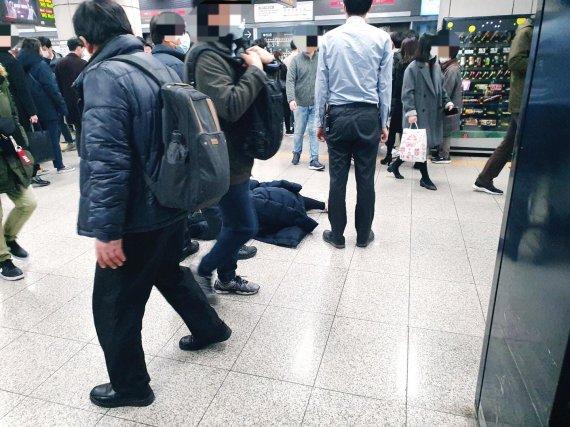 24일 오전 서울 지하철 9호선 당산역에 빈혈로 쓰러진 여성이 119 대원을 기다리며 역무원 옆에 누워있다. 이 장면을 목격한 시민 이모씨는 "지하철 안에서부터 여성이 힘들어 보였지만 혹시나 코로나19 감염자일까 싶어 아무도 도와주지 못했다"고 전했다. 독자제공
