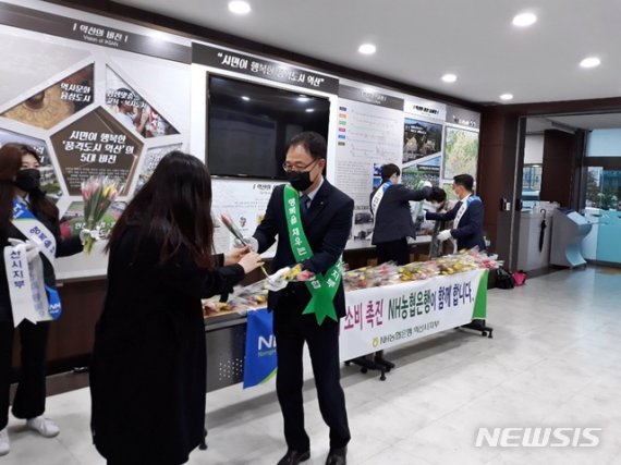 [익산=뉴시스] 강명수 기자 =NH농협 전북 익산시지부가 신종 코로나바이러스 감염증(코로나19) 여파로 인해 피해를 입고 있는 화훼 농가 돕기 위한 캠페인을 25일 시청에서 진행하고 있다. (사진 =농협 익산시지부 제공) 2020.02.25.photo@newsis.com