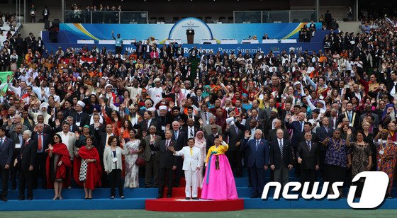 2014년 9월 17일 서울 잠실 올림픽주경기장에서 열린 종교대통합 만국회의(WARP·World Alliance of Religions Peace Summit) 개막식에서 이만희 하늘문화세계평화광복 대표와 김남희 여성그룹 대표가 기념사진을 찍고 있다. (사)하늘문화세계평화광복 제공) © 뉴스1