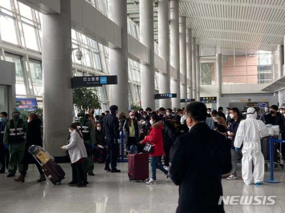 중국 산둥성 웨이하이국제공항에서 25일 방역요원들이 제주항공편으로 입국한 승객들을 버스에 태우고 있다. (사진=독자 제공) /사진=뉴시스화상