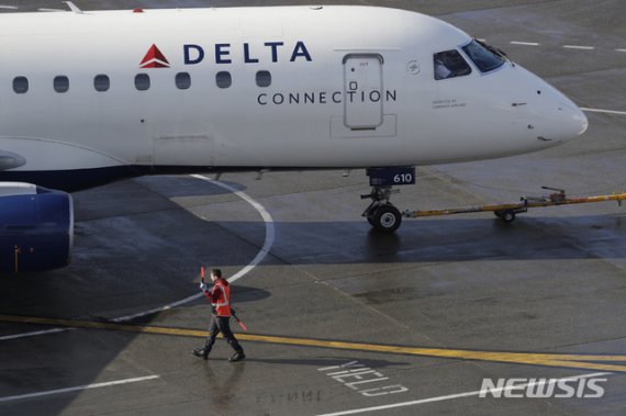 [시애틀=AP/뉴시스] 지난해 2월5일(현지시간) 미국 워싱턴주 시애틀의 시애틀-터코마 국제공항에서 한 근무자가 델타 항공기를 안내하고 있다. 2020.01.22.