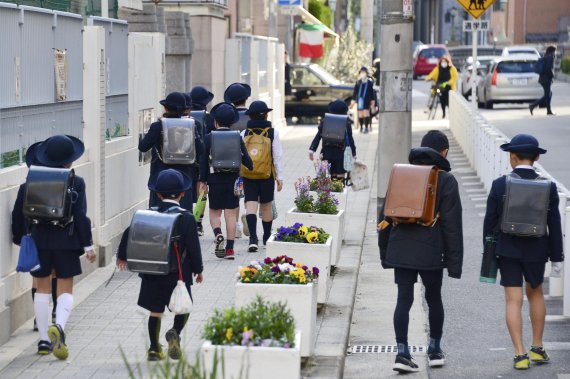 휴교령 직전인 지난 2월 오사카 지역에서 초등학생들이 등교를 하고 있다. 현재는 일본 전역의 상당수 학교들이 휴교 상태다. AP뉴시스