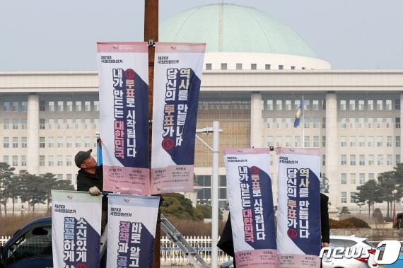 지난달 20일 오전 서울 영등포구 여의도 의사당대로 일대에서 서울시 선거관리위원회 관계자들이 오는 4월15일 실시되는 제21대 국회의원선거 투표 독려 현수기를 걸고 있다. 뉴스1