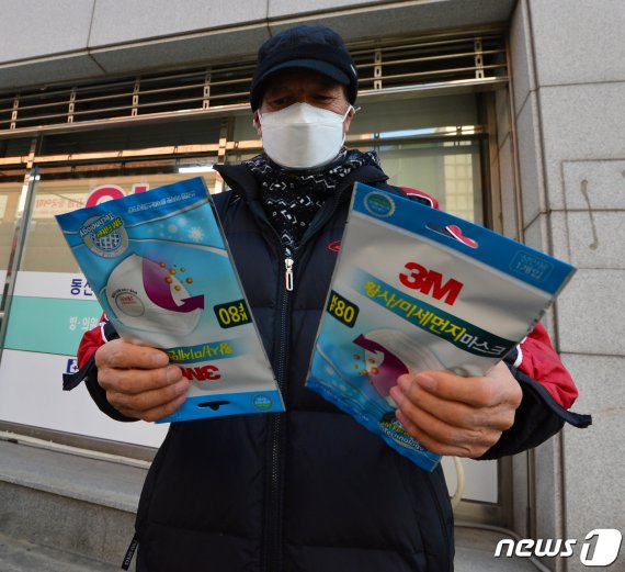 5일 오전 경북 포항시 남구 연일읍에 있는 한 약국에서 마스크를 구입한 시민이 내용물을 확인하고 있다. 포항시는 이날 공적 마스크를 관내 약국에서 판매를 시작한다. 2020.3.5/뉴스1 © News1 최창호 기자