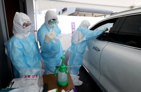 6일 경기 김포시장애인복지관 공영주차장에 마련된 코로나 19 이동 선별진료소에서 뉴고려병원 의료진들이 검사를 진행하고 있다. 뉴스1