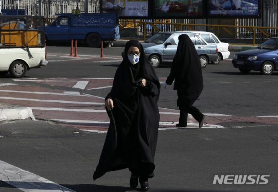 [테헤란=AP/뉴시스]4일(현지시간) 이란 테헤란 북부의 한 교차로에서 마스크를 쓴 여성이 길을 건너고 있다. 이란 보건부는 4일 정오 기준 신종 코로나바이러스 감염증(코로나19) 확진자가 586명 더 늘어 모두 2천922명이 됐으며 사망자는 15명 증가해 지금까지 92명이 숨졌다고 밝혔다.<div id='ad_body2' class='ad_center'></div> 2020.03.05.