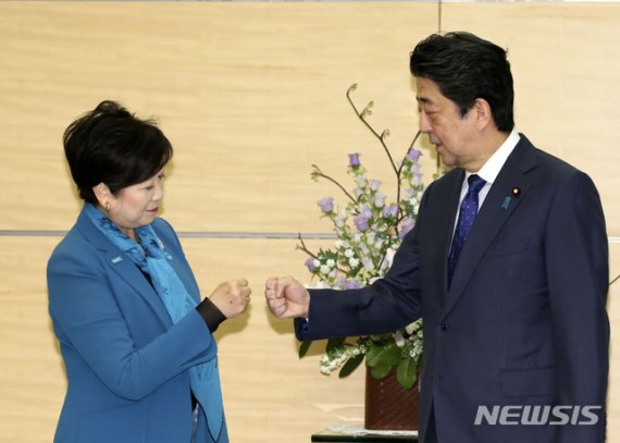 아베 신조(오른쪽) 일본 총리가 12일 총리관저에서 고이케 유리코 도쿄도지사를 만나 회담 전 주먹 인사를 하고 있다. 사진=AP 뉴시스