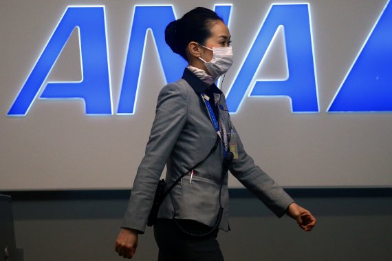 마스크를 쓴 여성이 간사이공항 아나항공 로고 앞을 지나가고 있다. 로이터 뉴스1