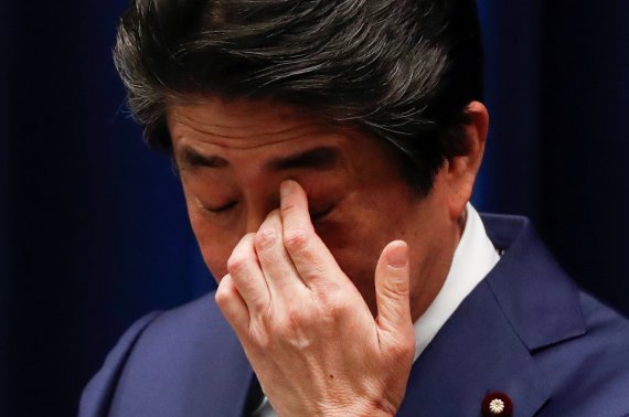 아베 신조 일본 총리가 지난 14일 총리 관저에서 열린 기자회견에서 손으로 눈을 만지고 있다. 로이터 뉴스1