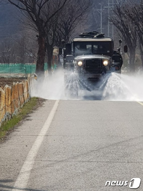 육군 37사단 화생방지원대가 생활치료센터인 충북 보은군 장안면 사회복무연수센터 앞 도로를 제독하고 있다.(보은군 제공).© 뉴스1