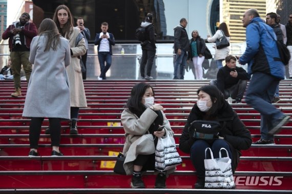 [뉴욕=AP/뉴시스]15일(현지시간) 신종 코로나바이러스 감염증(코로나19) 확진자가 미국에서 늘고 있는 가운데 일본인 관광객들이 마스크를 낀 채 타임스스퀘어에 앉아있다. 2020.03.16.