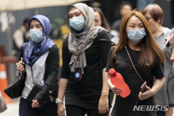 [쿠알라룸푸르=AP/뉴시스] 말레이시아 쿠알라룸푸르의 거리를 지난 5일(현지시간) 시민들이 마스크를 쓴 채 걷고있다. 2020.03.07.
