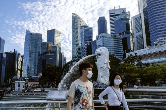 In this March 14, 2020, photo, a couple wearing face masks walk past the Merlion statue in Singapore. . (AP Photo/Ee Ming Toh) /뉴시스/AP /사진=