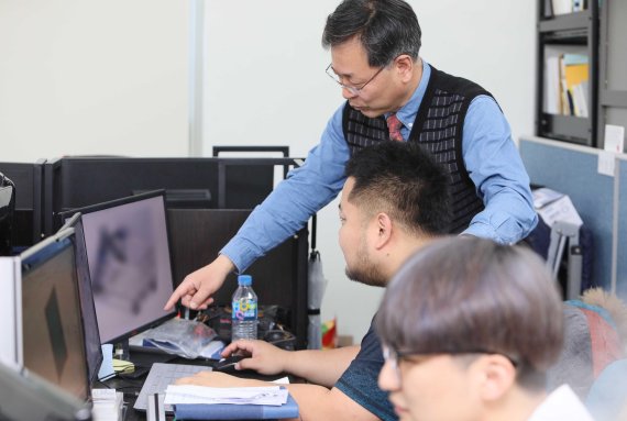 장병록 인하대 제조혁신전문대학원 교수와 연구원들이 김현태드림센터에 마련된 실험실에서 연구과제를 살피고 있다.