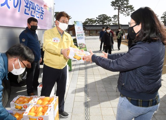 이철우 경북지사는 경북도가 실시 중인 '코로나19 극복 농산물 품앗이 완판운동'에 적극 동참, 고객에게 참외를 판매하고 있다. 사진=경북도 제공