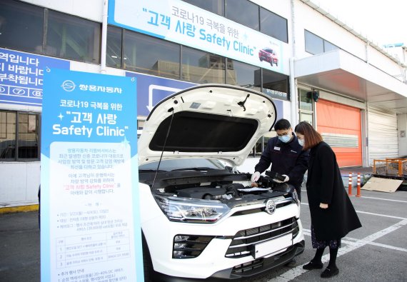 쌍용차 정비담당자가 서비스 네트워크를 방문한 고객과 정비 상담을 진행하고 있다.