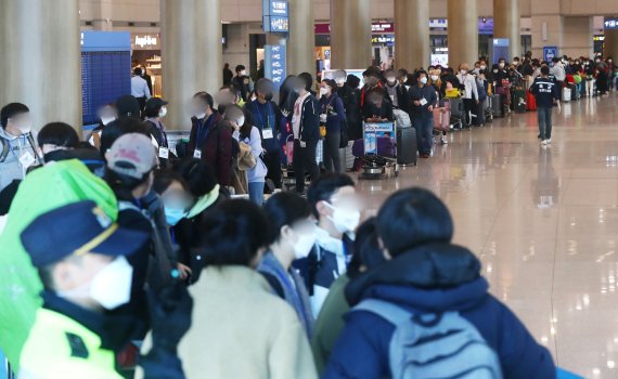 23일 인천국제공항 제1터미널에서 독일 프랑크푸르트발 여객기를 타고 입국한 승객들이 격리시설로 이동하는 버스를 타기 위해 줄지어 기다리고 있다. 정부는 유럽에서 코로나19가 크게 유행하자 22일 0시부터 유럽발 입국자에 대한 검역을 강화하고 있다. 뉴시스