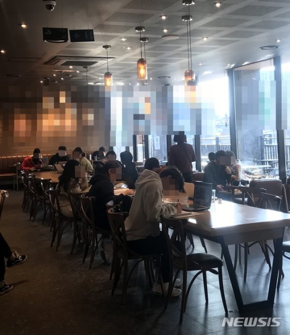 [울산=뉴시스] 구미현 기자 = 24일 오후 울산 중구의 한 프랜차이즈 카페 2층 매장에서 20~30대 학생과 직장인들이 다닥다닥 붙어 앉아 업무나 공부를 하고있다. 2020.03.25. photo@newsis.com