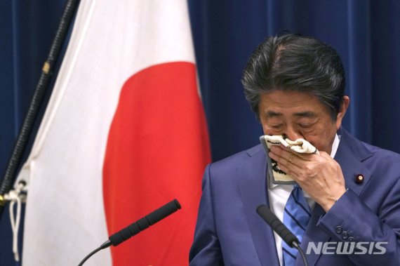 아베 신조 일본 총리가 14일 도쿄의 총리 사무실에서 기자회견을 진행하던 중 손수건으로 얼굴을 닦고 있다.