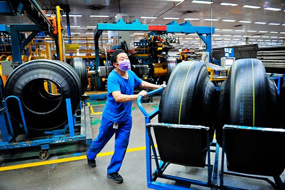 중국 산둥성 칭다오시에 위치한 공장에서 마스크를 낀 노동자가 제조된 타이어를 옮기고 있다. AP뉴시스