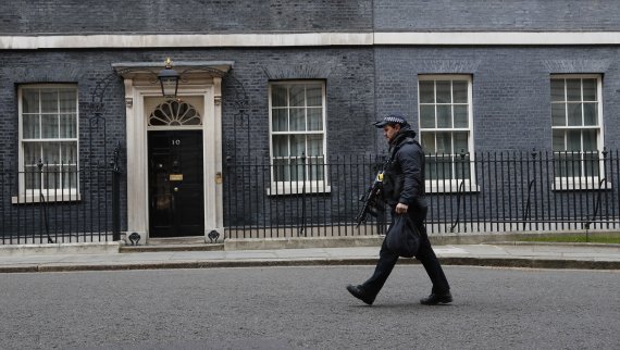 A police officer walks in Downing Street in London after it was announced that British Prime Minister Boris Johnson has tested positive for the new coronavirus, Friday, March 27, 2020. Johnson's office said Friday that he was tested after showing mild symptoms, Downing Street says Johnson is self-is