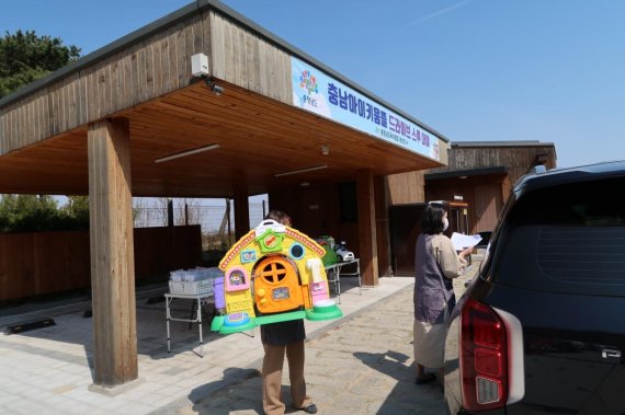 충남 홍성군 홍북읍의 맞춤형 보육 시설인 충남아이키움뜰 직원들이 드라이브 스루 형식으로 주민들에게 장난감과 책을 대여하고 있다.