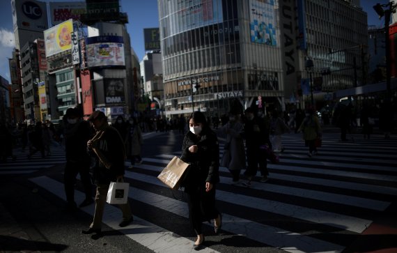 마스크를 쓴 여성이 도쿄 번화가 시부야 횡단 보도위에 있다. 로이터 뉴스1