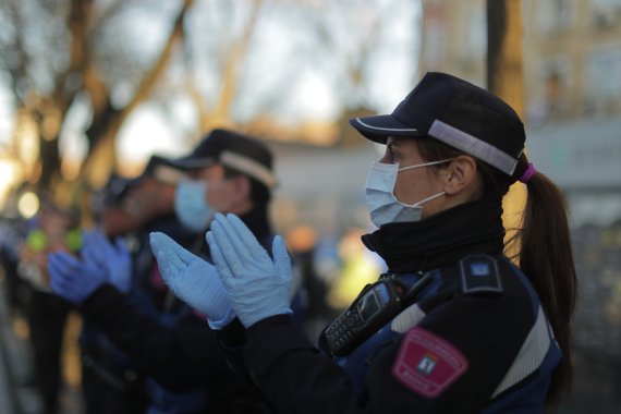 Police officers applaud as people react from their houses in support of the medical staff that are working on the COVID-19 virus outbreak at the Gregorio Maranon hospital in Madrid, Spain, Wednesday, April 1, 2020. (AP Photo/Manu Fernandez) /뉴시스/AP /사진=