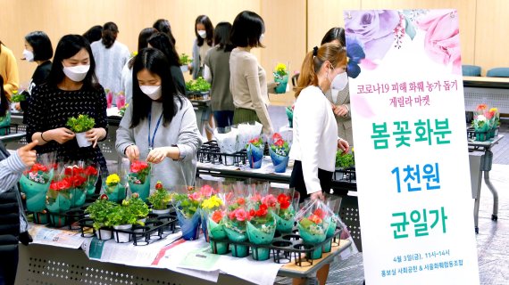 3일 서울 광화문 우리카드 본사에서 진행된 '화훼농가 돕기 게릴라 마켓' 행사에서 우리카드 임직원들이 꽃 화분을 구매하고 있다. 우리카드 제공