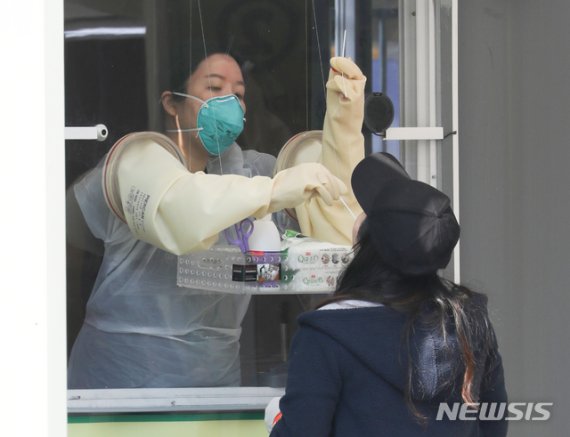 해외입국자 전용 코로나19 워킹스루 선별진료소가 설치된 3일 오후 서울 잠실종합운동장에서 의료진이 해외 입국자들의 검체 채취 하고 있다. 뉴시스