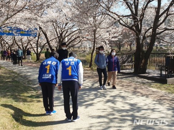 [수원=뉴시스] 이병희 기자 = 백혜련(경기 수원을·더불어민주당) 후보가 선거운동 시작 뒤 첫 주말인 4일 남편과 함께 황구지천에서 시민들에게 지지를 호소하고 있다. 2020.04.04. heee9405@naver.com