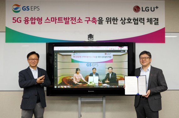 조원석 LG유플러스 기업신사업그룹장 전무(오른쪽)와 이강범 GS EPS 발전부문장 전무(TV속 가운데) 등 주요관계자들이 기념 촬영하고 있다. LG유플러스 제공