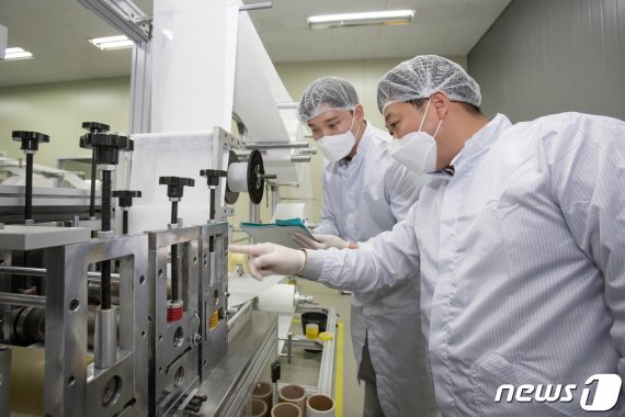 대전에 위치한 마스크 제조기업 '레스텍' 직원들과 삼성전자 스마트공장지원센터 멘토가 원단투입 공정을 점검하고 있다. /뉴스1