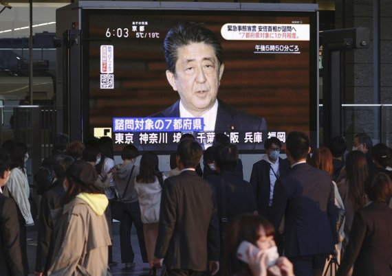 오사카 시민들이 6일 오후 대형 모니터를 통해 아베 신조 일본 총리의 긴급사태 선언 예고 기자회견을 지켜보고 있다. 아베 총리는 도쿄와 더불어 오사카도 긴급사태 선언 지역이라고 밝혔다. AP뉴시스