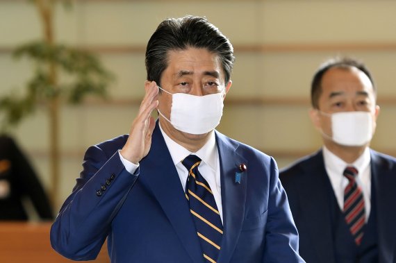 아베 신조 일본 총리가 7일 자신의 집무실인 총리관저에 도착해 손을 들어 인사를 하고 있다. AP뉴시스