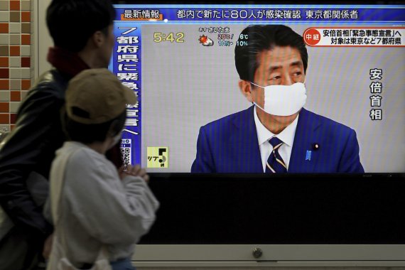7일 오후 아베 신조 일본 총리의 긴급사태 선언 발표를 행인들이 대형 모니터를 통해 보고 있다. AP뉴시스