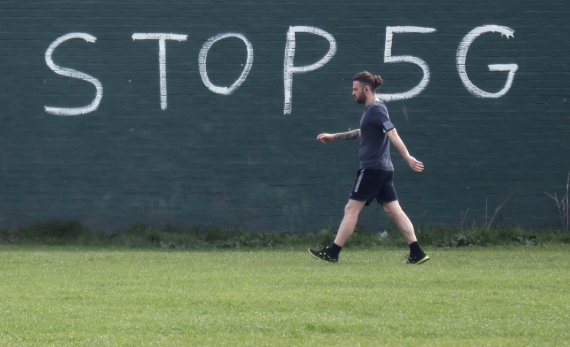 A man exercising during lockdown to combat an outbreak of coronavirus disease (COVID-19) walks past a graffiti that reads 'STOP 5G' in London, Britain, April 8, 2020. REUTERS/Russell Boyce /REUTERS/뉴스1 /사진=