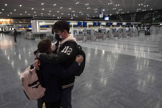 일본 정부의 입국금지 조치가 본격화되기 직전인 지난 4월 1일 나리타 공항에서 한 커플이 포옹을 하고 있다. 이때도 이미 코로나19 확산 사태로 나리타공항은 텅비어 있다. AP뉴시스