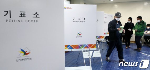 제21대 국회의원선거 투표가 시작된 15일 오전 서울 종로구 하비에르 국제학교에 마련된 평창동 제3투표소에서 마스크를 쓰고 비닐장갑을 낀 시민이 투표를 마친 후 기표소를 나서고 있다.
