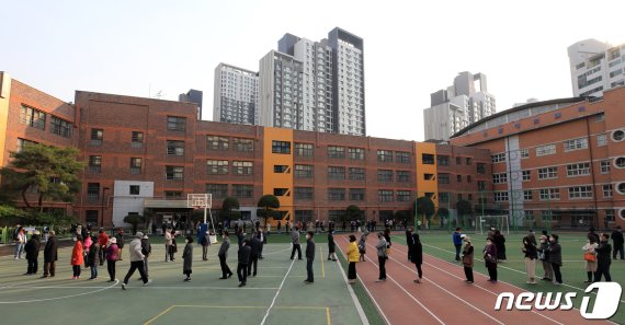 제21대 국회의원선거일인 15일 오전 서울 서초구 원명초등학교에 마련된 투표소에서 유권자들이 투표를 하기 위해 길게 줄을 서고 있다.
