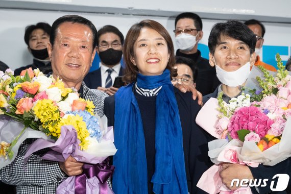 고민정 더불어민주당 서울 광진구을 후보가 16일 서울 광진구 선거사무소에서 21대 국회의원선거 당선을 확정지은 후 아버지 고영수씨(왼쪽), 남편 조기영 시인과 꽃다발을 들고 기념촬영을 하고 있다. 2020.4.16/뉴스1 © News1 유승관 기자