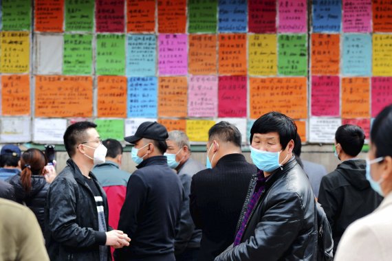 중국 동부 산둥성 칭다오에 있는 한 노동시장에서 일을 구하는 사람들이 마스크를 착용한 채 구인광고를 보고 있다. 코로나19 확산 여파로 중국은 올해 처음으로 분기 경제성장률이 마이너스를 기록했다. 17일 중국 국가통계국에 따르면 중국의 올해 1·4분기 국내총생산(GDP) 증가율은 -6.8%로, 이는 1992년 이후 28년 만에 가장 낮은 수치다. AP 뉴시스