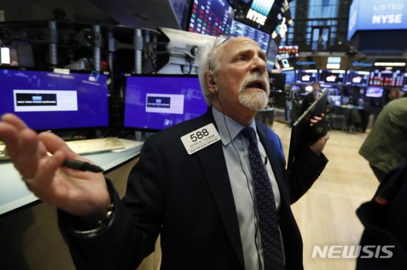 [뉴욕=AP/뉴시스]지난 달 9일(현지시간) 미국 뉴욕증권거래소(NYSE)에서 한 트레이더가 전광판을 보고있다. 이날 뉴욕증시는 코로나 19와 유가급락 영향으로 대폭락했다. 2020.03.10