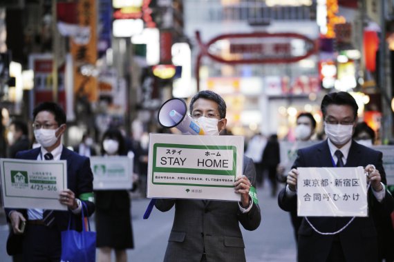 지난 24일 도쿄 신주쿠에서 코로나19 확산을 피해 '집에 머물러달라'는 내용의 가두캠페인을 벌이는 도쿄도청 직원들. AP뉴시스